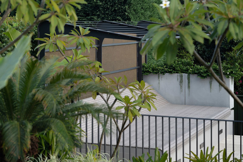 Landscaping Ideas - In the garden and beside the pool, a custom-designed bench will soon be covered by a vine, creating a quiet place to relax. #OutdoorBench #LandscapingIdeas #Pergola