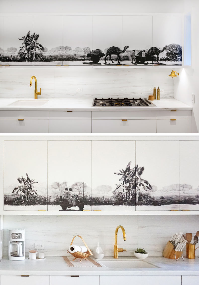 Kitchen Ideas - A black and grey mural has been added to the upper cabinets in this white and wood modern kitchen, creating a central focal point for the open plan interior.  #KitchenIdeas #KitchenCabinets #Mural #Art #KitchenDesign #ModernKitchen