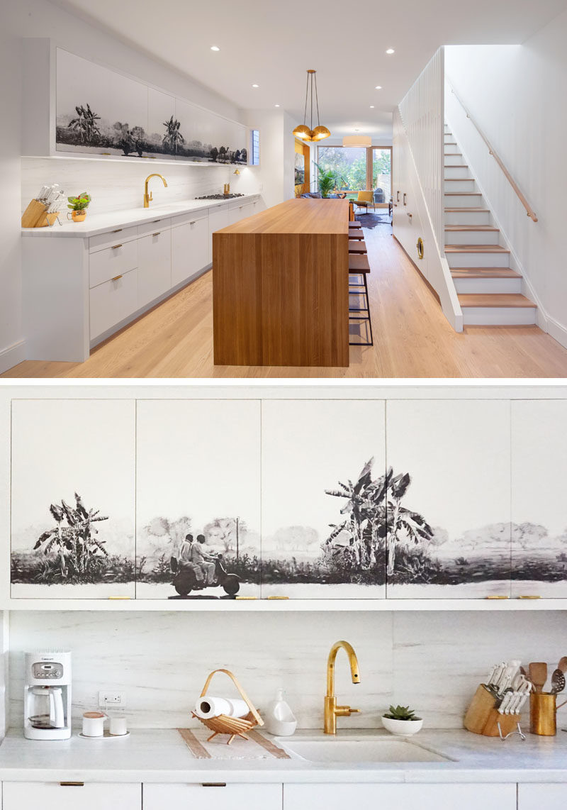 Kitchen Ideas - A black and grey mural has been added to the upper cabinets in this white and wood modern kitchen, creating a central focal point for the open plan interior.  #KitchenIdeas #KitchenCabinets #Mural #Art #KitchenDesign #ModernKitchen