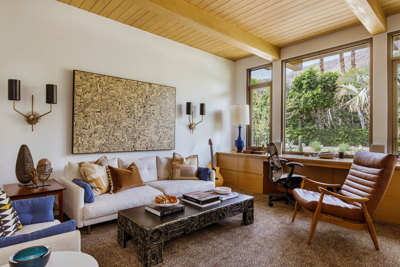 This home office features a desk that reaches from wall to wall, and a large window perfectly frames the tree views. #HomeOffice #Windows #Desk