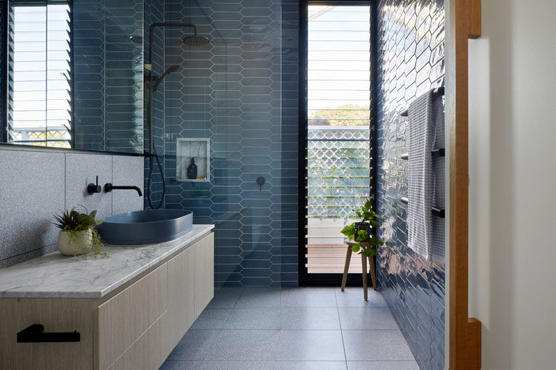 Bathroom Ideas - In this modern bathroom, blue picket tiles have been used to add color to the space, while in the shower, a built-in shelf complements the floating vanity countertop. #BlueBathroom #BathroomIdeas #TileIdeas