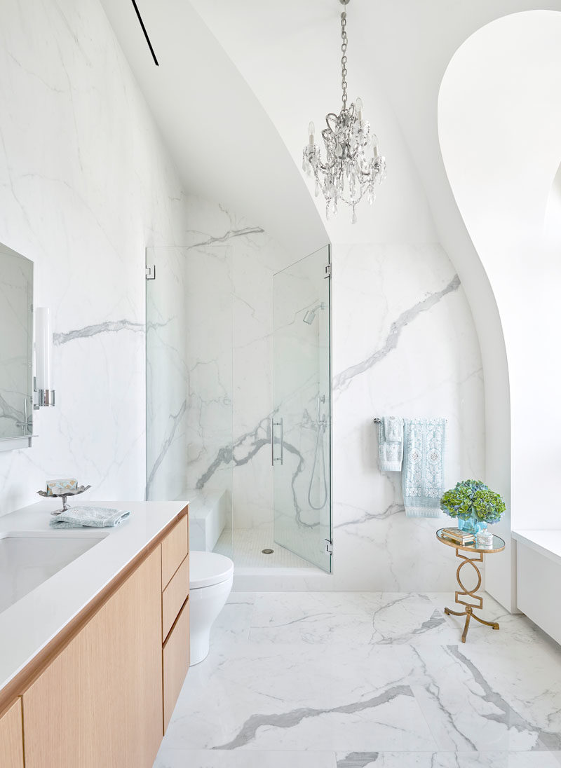 Bathroom Ideas - This modern bathroom has high arches and vaulted ceilings, while the shower has a built-in bench, and the shower door sits flush with the wall. #BathroomDesign #ModernBathroom