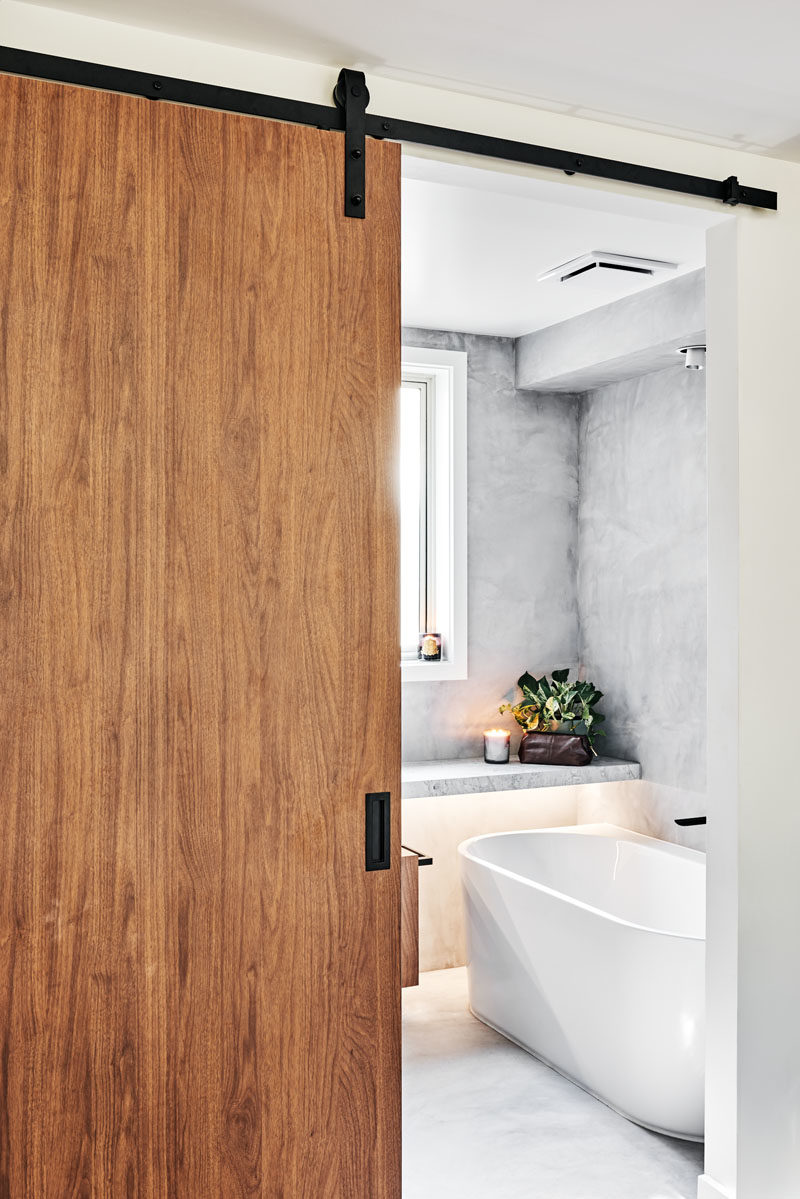 Door Ideas - A modern barn door with matte black hardware opens to reveal the bathroom. #ModernBarnDoor #DoorIdeas