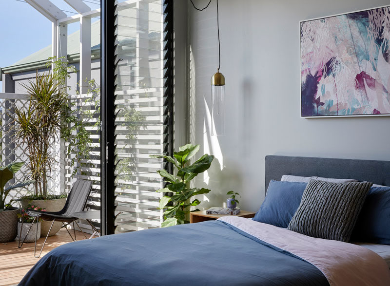 Bedroom Ideas - This modern bedroom opens up to the balcony with views of the backyard. Louvre windows allow the movement of air even when the door's closed. #BedroomIdeas #ModernBedroom #LouvreWindows #Windows