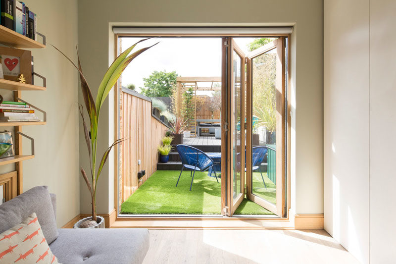 Door Ideas - This modern guest bedroom has wood-framed folding glass doors that open to the updated yard. #GuestBedroom #DoorIdeas #FoldingDoors