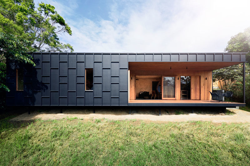 House Siding Ideas - The exterior of this modern house is covered in black fibre cement sheets with matching black battens, that create dimension and define the window locations. #ModernHouse #BlackSiding #Architecture #HouseSidingIdeas