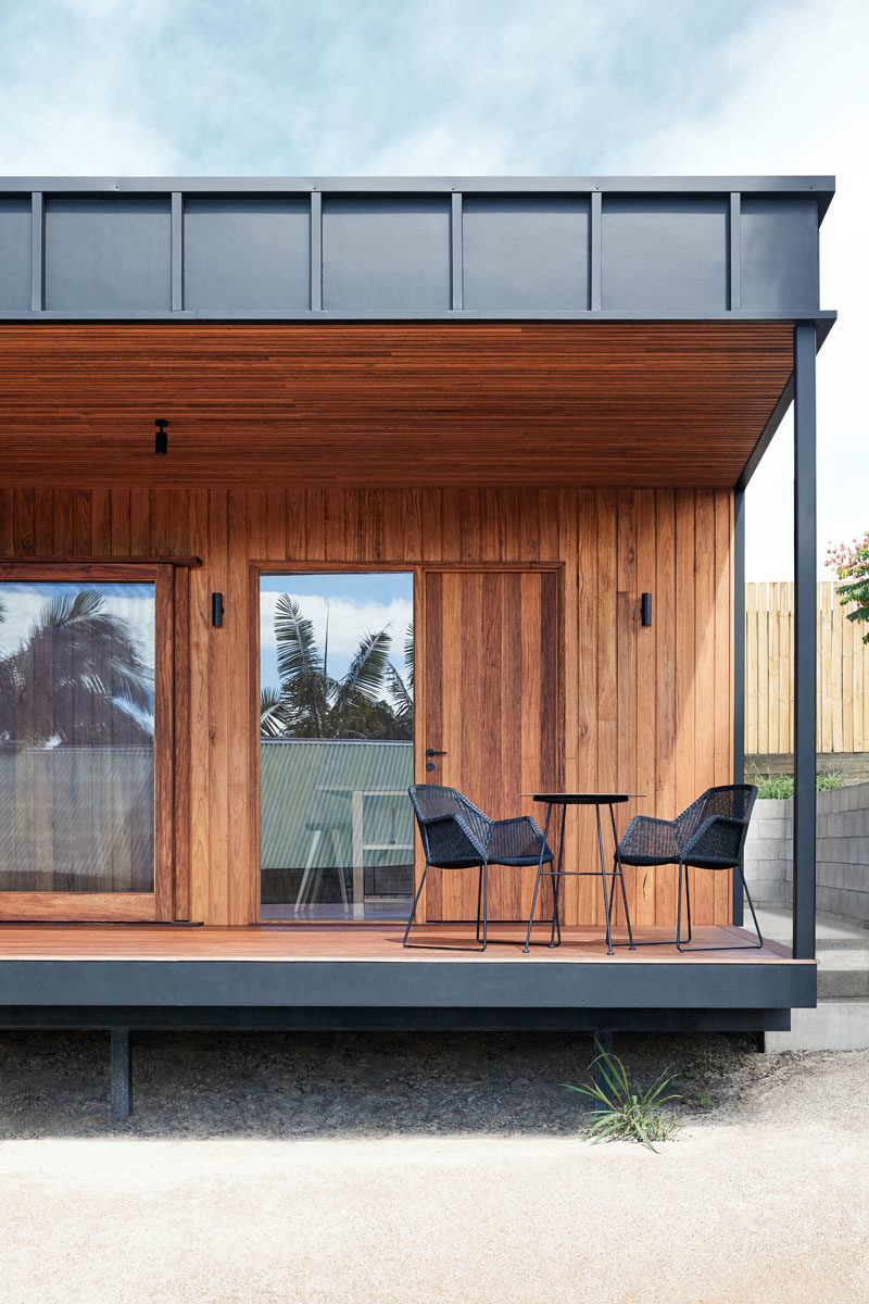 This small black and wood house has a covered porch off the living room and kitchen. #CoveredPorch #Deck #ModernArchitecture