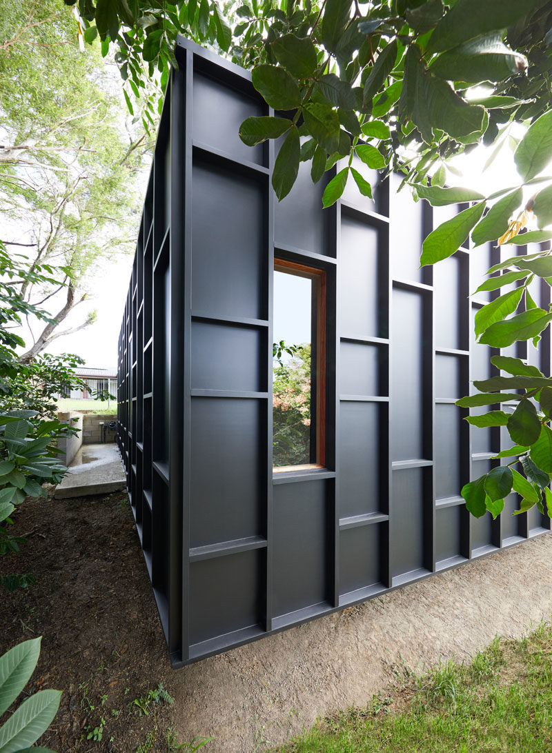 House Siding Ideas - The exterior of this modern house is covered in black fibre cement sheets with matching black battens, that create dimension and define the window locations. #ModernHouse #BlackSiding #Architecture #HouseSidingIdeas