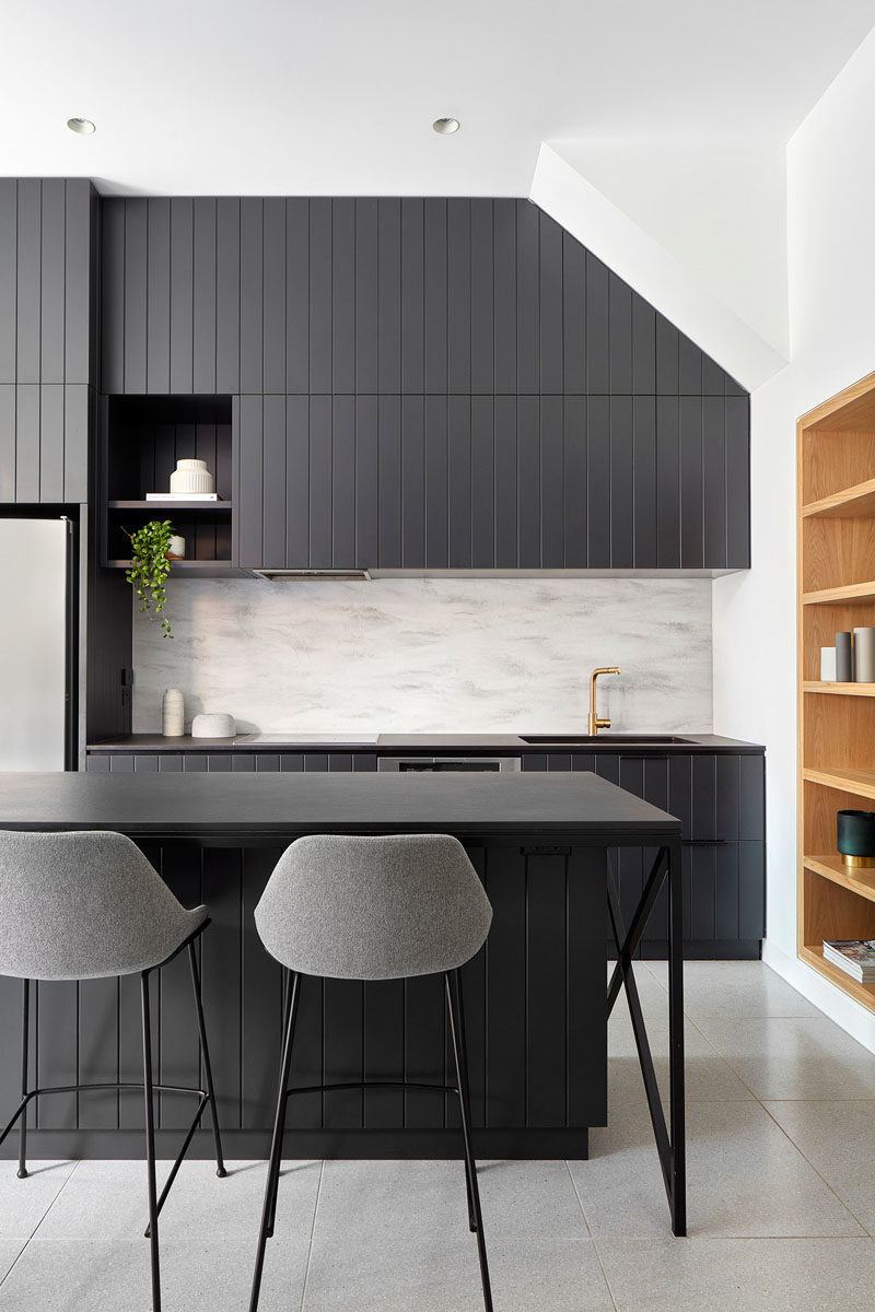 Kitchen Ideas - Matte black cabinets have been paired with dark countertops, creating a modern kitchen that contrasts the white walls. #BlackKitchen #KitchenIdeas #MatteBlackCabinets