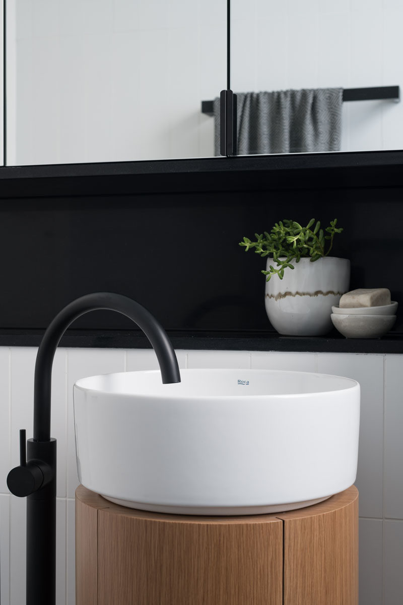 Bathroom Ideas - This modern bathroom has been designed with a minimalist pedestal sink, a walk-in shower, and black accents. #BathroomIdeas #BathroomDesign #ModernBathroom