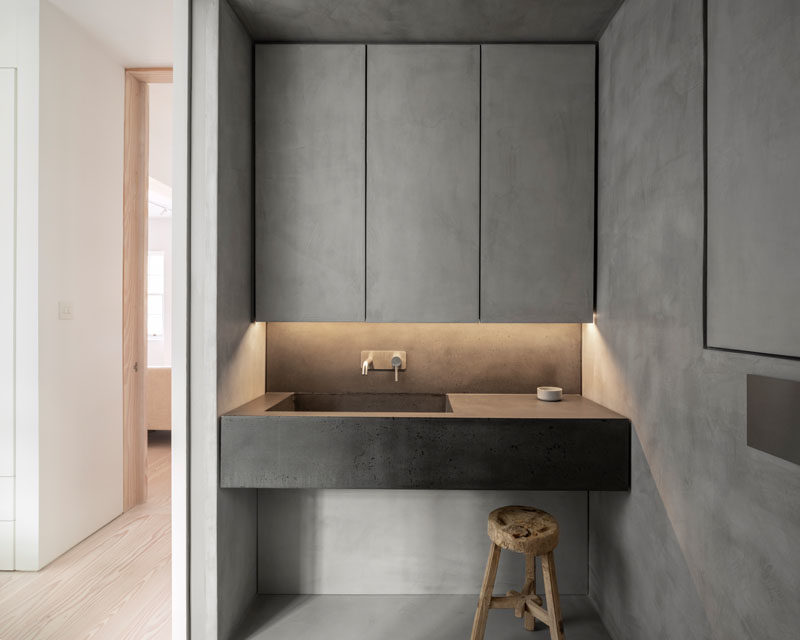 Bathroom Ideas - This modern bathroom has a seamless microcement finish, that's featured on the walls, floor, ceiling, and cabinetry, while a bespoke concrete vanity units has an integrated sink and brushed stainless steel fixtures. #BathroomIdeas #ModernBathroom #Microcement #ConcreteBathroom