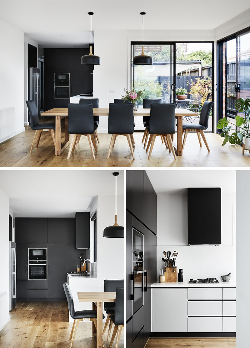 This modern interior features a large 8 person dining table, and a minimalist black and white kitchen. #ModernInterior #ModernDiningRoom #ModernKitchen #BlackKitchen