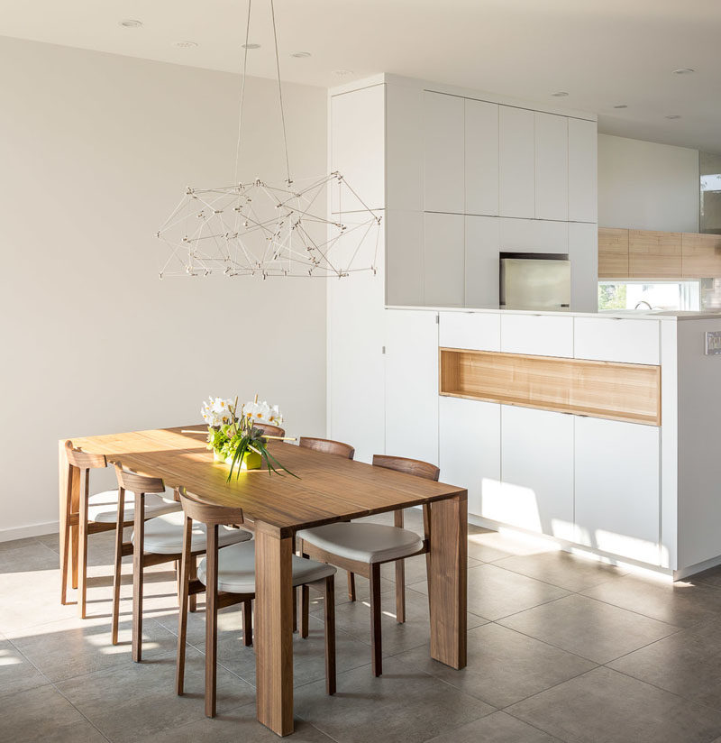 Flooring Ideas - Large-format, grey tiles, like in this modern dining area, have been used to create a a unified appearance throughout the second level living space of this house. #FlooringIdeas #GreyFlooring #TileFlooring #ModernFloorTiles