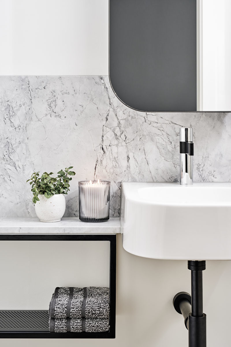 Bathroom Ideas - In this modern bathroom, a white vanity has been combined with grey stone, and black accents. #BathroomIdeas #BathroomDesign #ModernBathroom