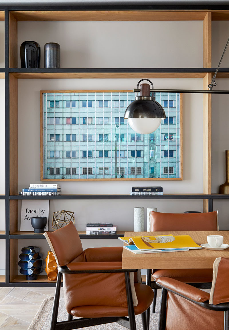 Shelving Ideas - In this modern conference room, the black-front wood shelves perfect frame the artwork, and complement the black frames of the leather chairs. #Shelving #ShelvingIdeas #ConferenceRoom #WorkplaceIdeas