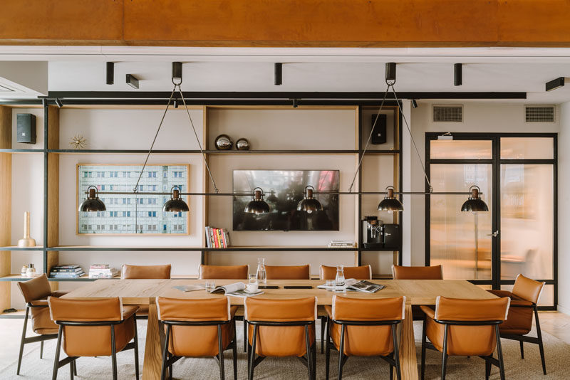 Shelving Ideas - In this modern conference room, the black-front wood shelves perfect frame the artwork, and complement the black frames of the leather chairs. #Shelving #ShelvingIdeas #ConferenceRoom #WorkplaceIdeas