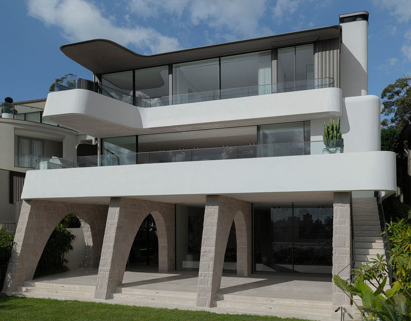 This modern hillside house in Sydney, Australia, features sandstone arches, and a cantilevered balcony. #ModernHouse #ModernArchitecture #CantileveredBalcony #SandstoneArches