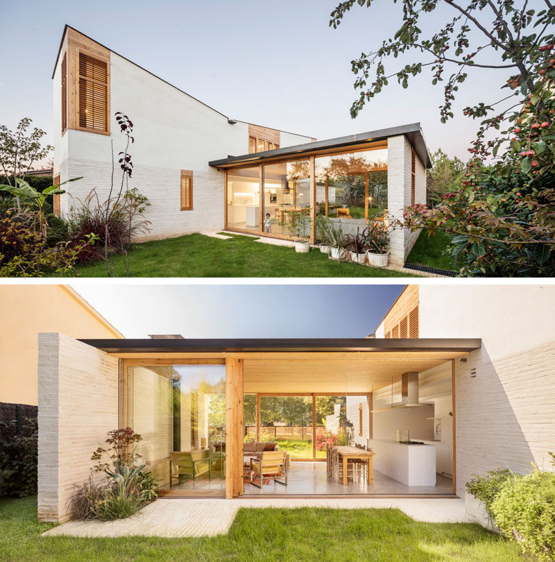 The horizontal component of this modern house has large wood-framed sliding glass walls that open to the garden on both sides. #GlassWalls #SldiingGlassDoors