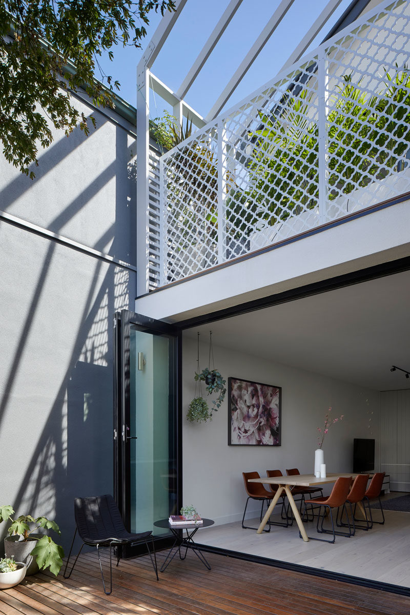 Folding doors connect the interior spaces of this renovated house with a wood deck, creating an indoor / outdoor living environment. #FoldingDoors #Deck