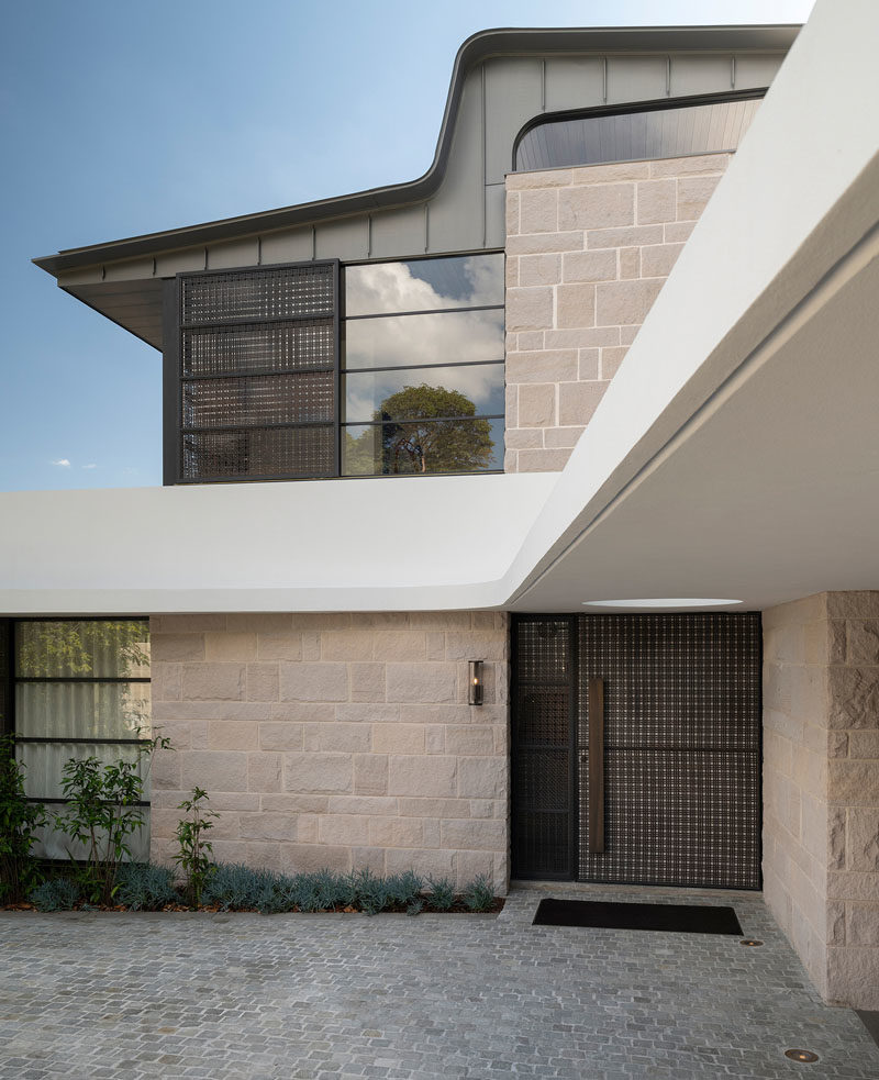 Front Door Ideas - This modern front door has a brass woven ribbon mesh exterior, and a travertine slab interior. #ModernFrontDoor #DoorIdeas #FrontDoor