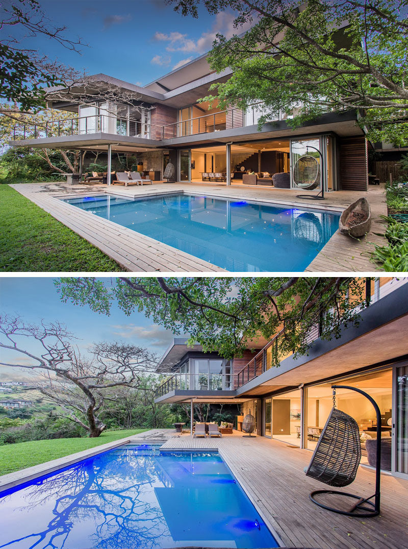 Large sliding glass doors open the main floor of this modern house to the yard, swimming pool and its surrounding deck. #SwimmingPool #ModernHouse #Deck #OutdoorLivingRoom