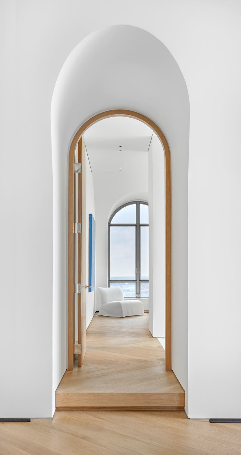 This modern penthouse apartment features vaulted ceilings, arched doorways and windows, and oversized oak flooring. #Windows #ArchedDoorway #VaultedCeiling