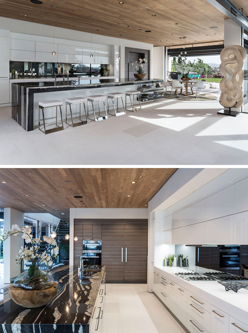 Kitchen Ideas - In this modern kitchen, a large island provides ample countertop space and room for seating, while a mirrored backsplash reflects the view, and a wood ceiling adds warmth to the open floor plan. #KitchenIdeas #ModernKitchen #LargeKitchenIsland