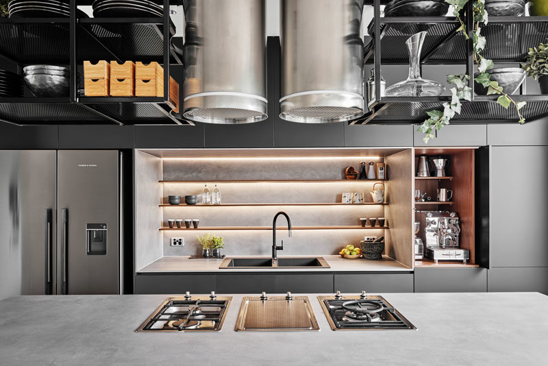 Kitchen Ideas, Stainless steel elements, metal shelving surrounding exposed exhaust vents, and a heavy use of greys, charcoals and blacks, make this modern kitchen bold, masculine, and industrial. #ModenKitchen #KitchenIdeas #ModernIndustrial