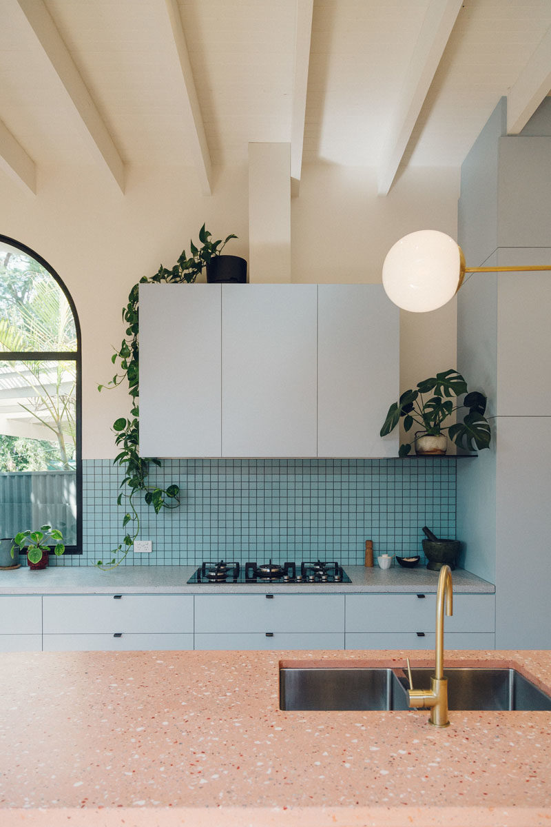 Kitchen Ideas - This modern kitchen features light blue cabinets with a blue tiled backsplash, and a large island with gold hardware. #KitchenIdeas #KitchenDesign #BlueKitchen #BlueCabinets