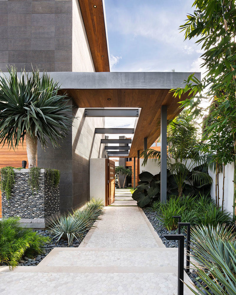 Landscaping Ideas - A partially covered path at the side of this modern house guides visitors through the gate and into the home. #Landscaping #Modernlandscaping #ModernPath #LandscapingIdeas