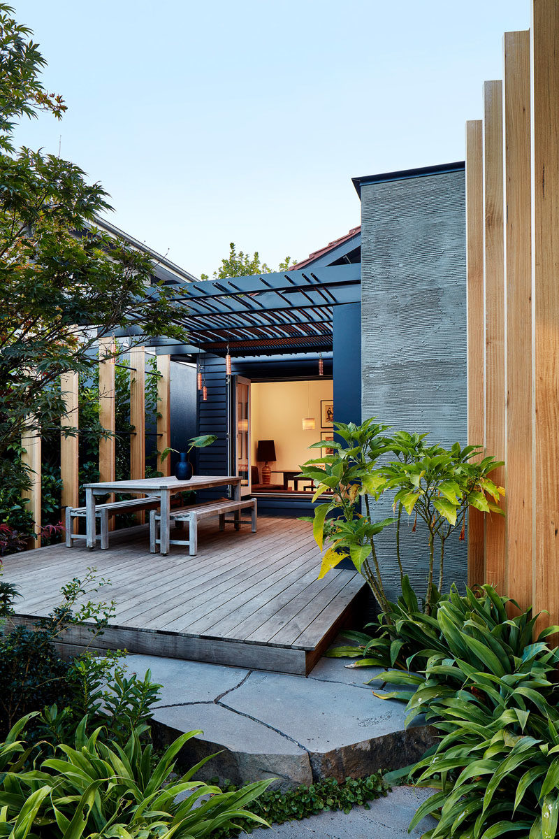 Folding glass doors open to a deck that expands the interior spaces of this modern house, creating an indoor / outdoor living area. #Deck #OutdoorDining #ModernPergola