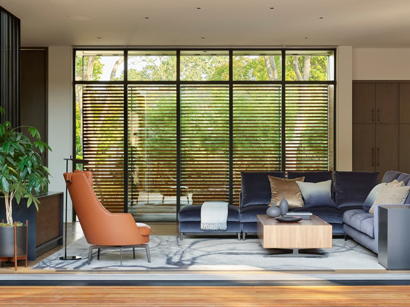 A series of metal and wood sunshades, like in this modern living room, provide the interiors with protection from the sun, without giving up the views. #WoodScreens #LivingRoom #ModernInterior