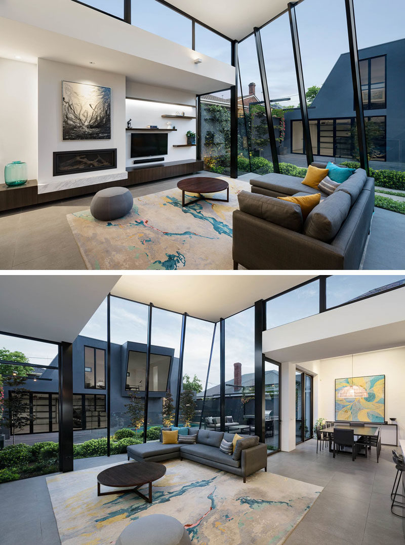 Window Ideas - At the end of the hallway in this modern house, there's an open plan living room, dining room, and kitchen, with soaring ceiling heights and floor-to-ceiling windows, that introduce a sense of space, light and scale to the residence. #ModernInterior #WindowIdeas #WindowDesign #LivingRoom #LivingRoomIdeas