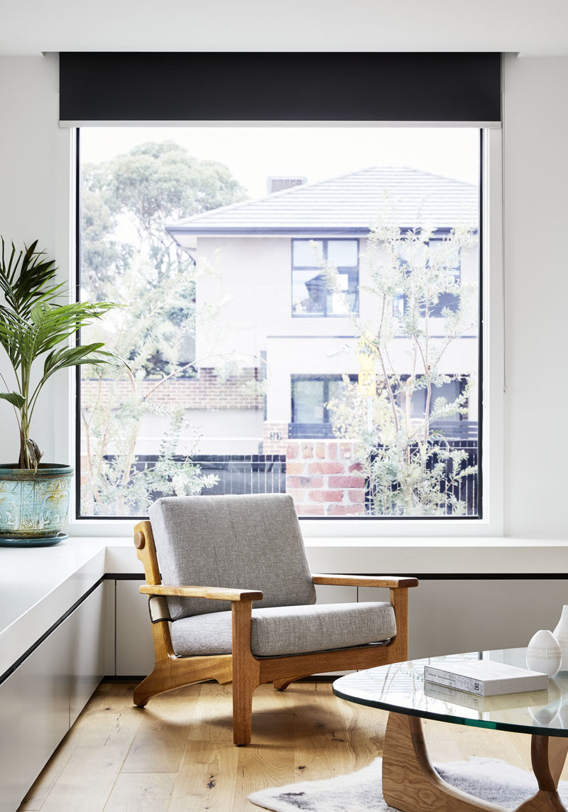 This large black-framed window provides views of the front garden and the street, while underneath the window, cabinets have been built to wrap around the corner of the living room. #Window #LivingRoom #Storage