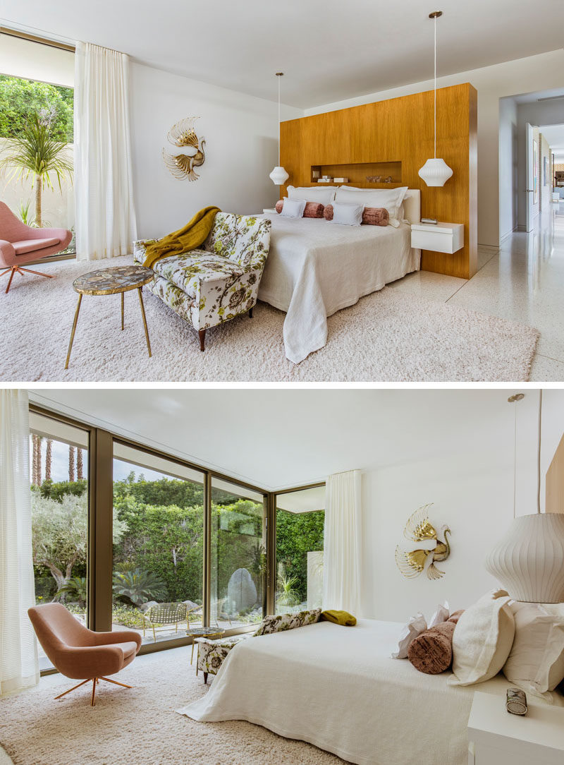 In this master bedroom, a wood wall with a shelf provides a backdrop for the bed, while a sliding glass door opens to a private patio. #MasterBedroom #BedroomIdeas