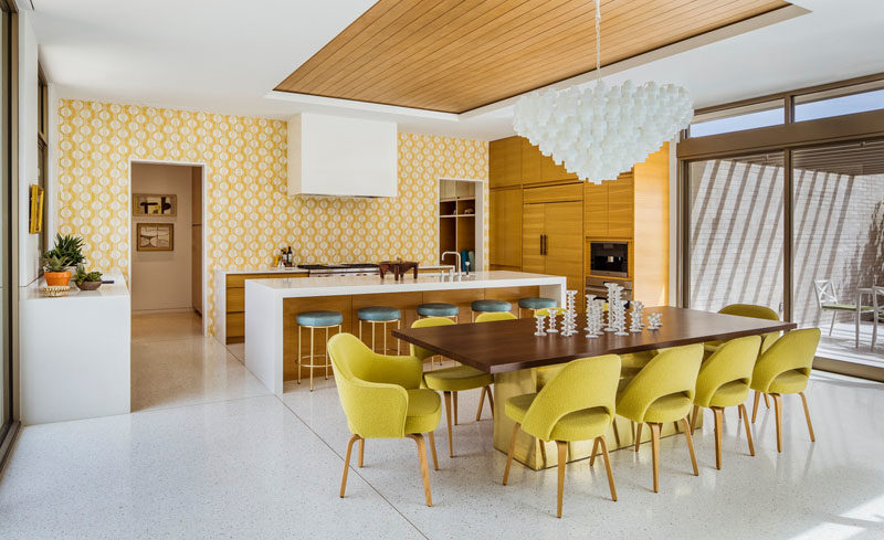 Pastel yellow wallpaper in this kitchen complements the dining chairs, and adds a pop of color to the interior. #Kitchen #Yellow #InteriorDesign