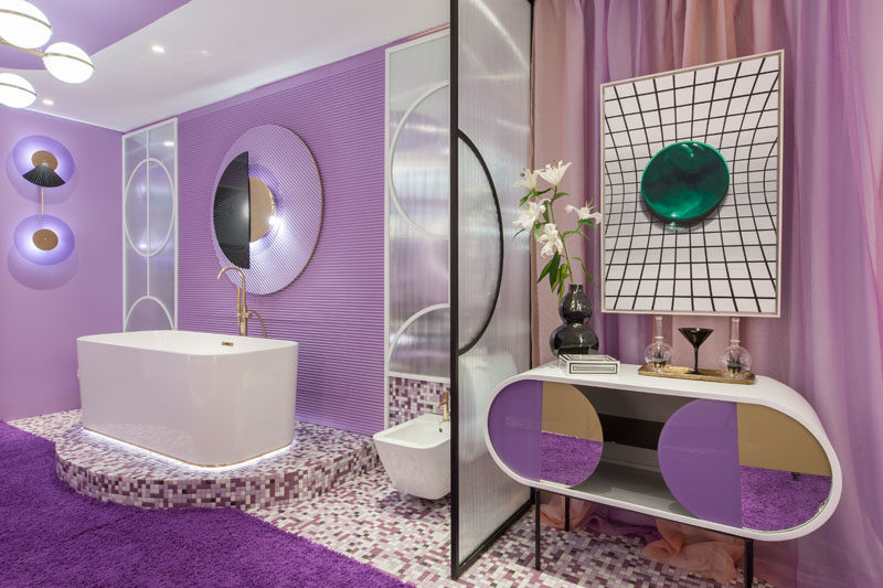 This purple hotel suite features a delicate glass partition that separates the bathroom from the bedroom. #Purple #PurpleInterior #PurpleBathroom