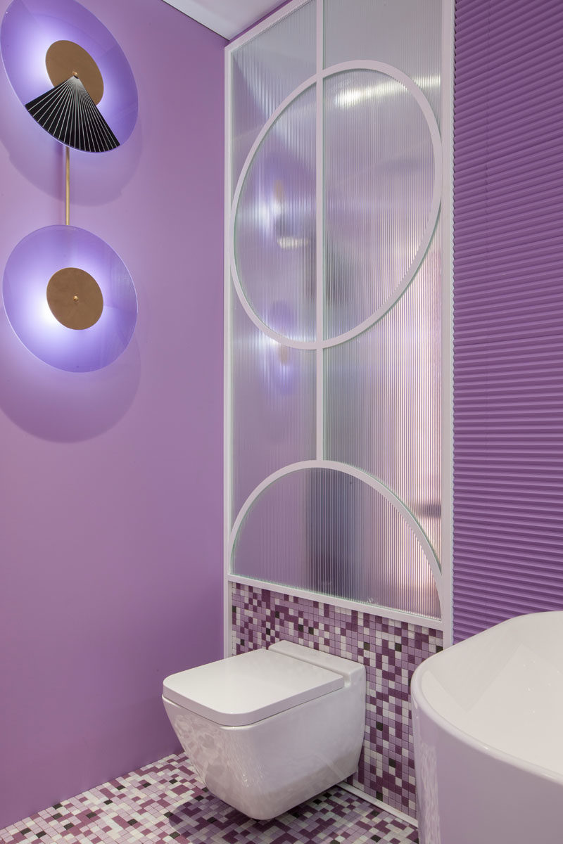 Decorative wall lighting provides an artistic accent in this modern hotel suite, where purple is the main color. #ArtisticLighting #LightingDesign