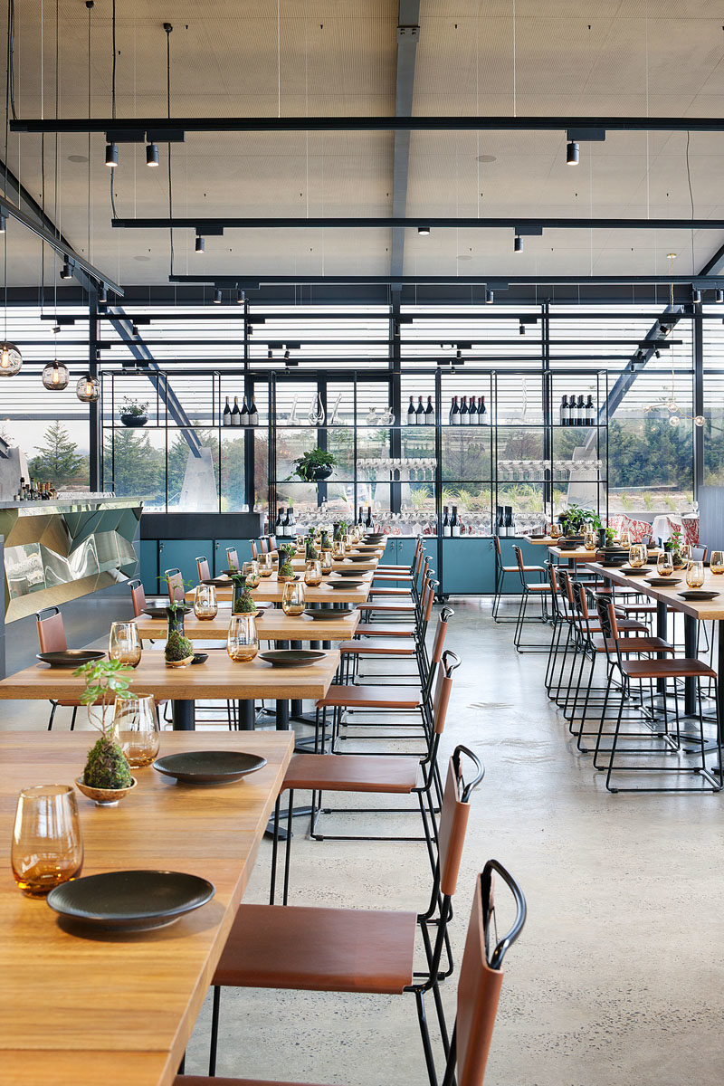 Restaurant Ideas - In the casual dining area of this modern winery restaurant, solid wood tables are complemented by leather seating. #RestaurantDesign #RestaurantIdeas #InteriorDesign #HospitalityDesign #Winery