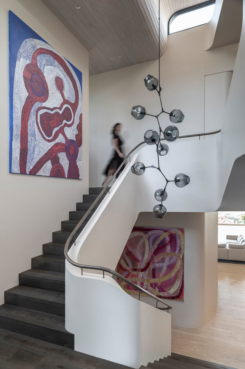 Stair Ideas - This modern staircase features a Lindsey Adelman branching bubble chandelier, while the paintings are ‘Antara’ by Betty Kunita Pumani and ‘Sweets’ by Ildiko Kovacs.  #StairIdeas #Staircase #InteriorDesign