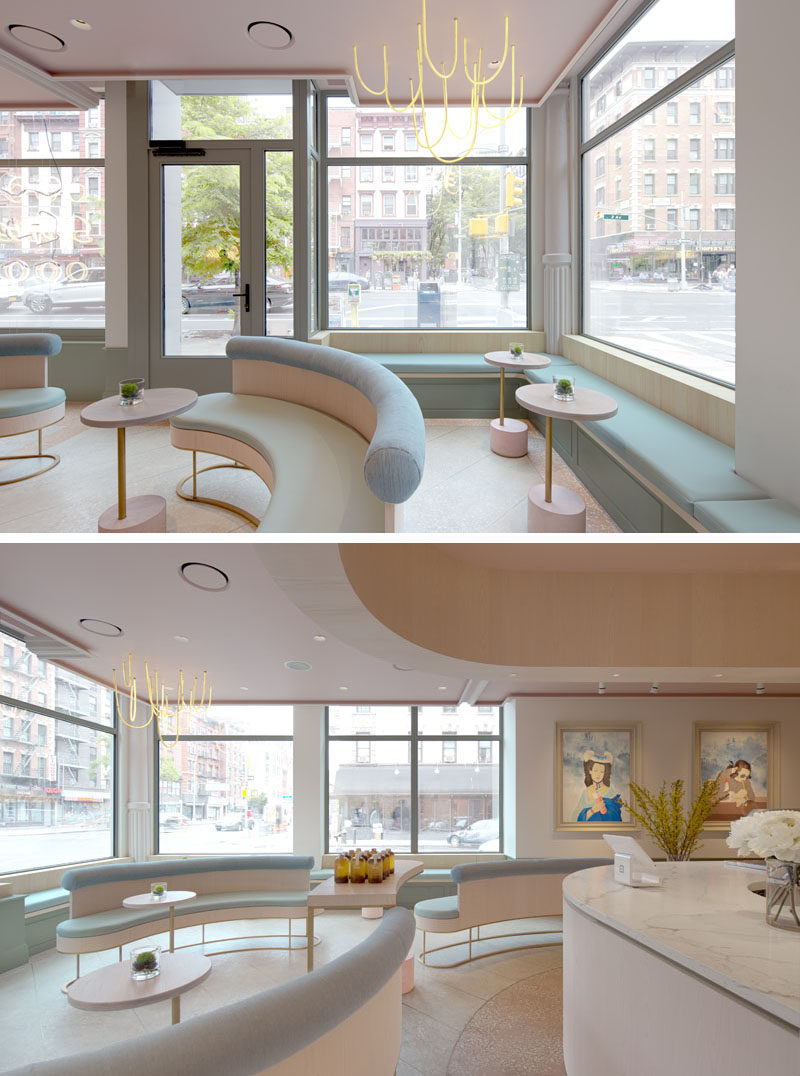 The modern gallery-like interior of this tea store, has light pink and blue accents, and features built-in benches that line the windows and walls. #TeaStore #InteriorDesign #Interiors #Cafe #Seating