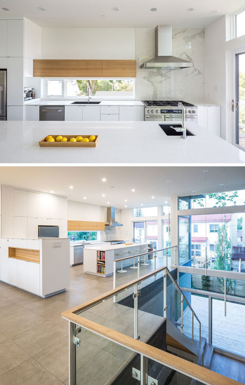 Kitchen Ideas - In this modern kitchen, minimalist white cabinets and light wood accents help keep the kitchen bright, while a sliding door opens to a balcony that overlooks the yard. #ModernKitchen #KitchenIdeas #WhiteKitchen