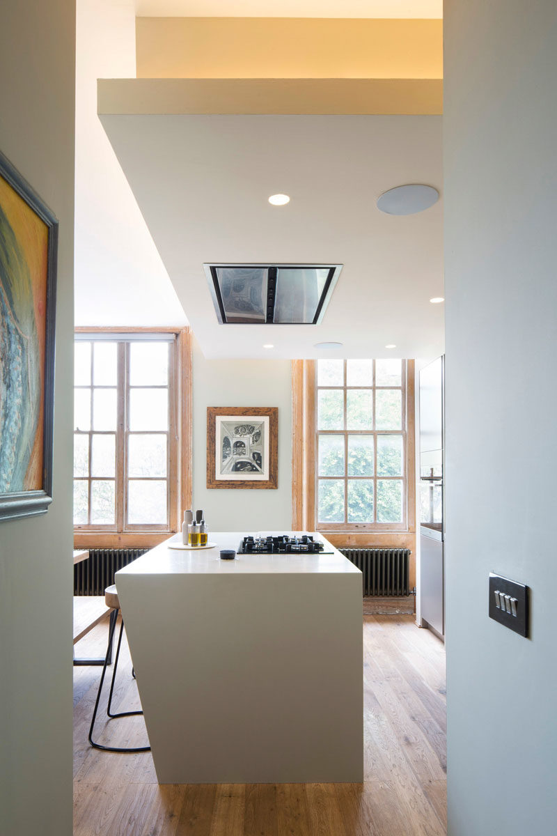 The interior of the building has received a bright update, with the main social areas of the house designed to take advantage of the large windows, while hidden lighting above the kitchen adds a warm glow to the room. #OpenPlan #Kitchen #LivingRoom #Dining #ModernInterior