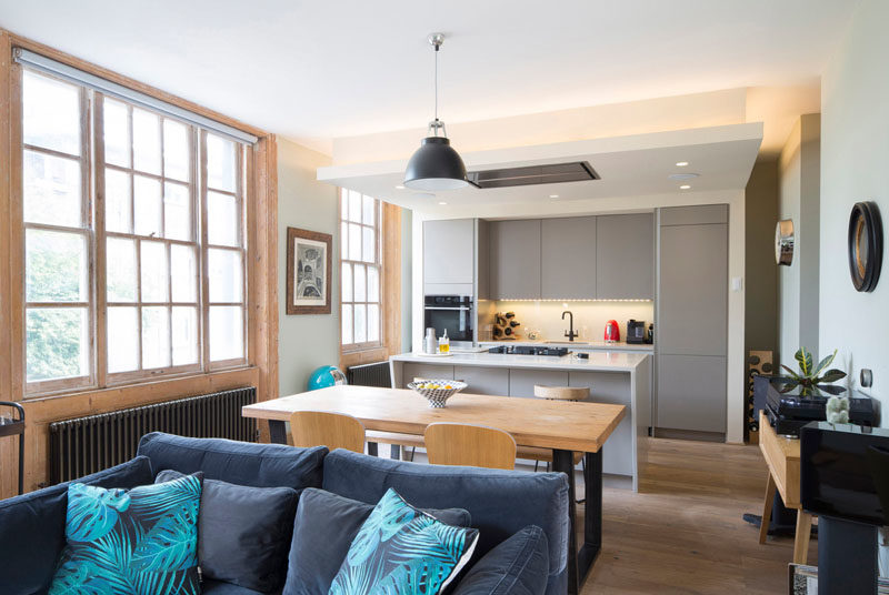 The interior of the building has received a bright update, with the main social areas of the house designed to take advantage of the large windows, while hidden lighting above the kitchen adds a warm glow to the room. #OpenPlan #Kitchen #LivingRoom #Dining #ModernInterior