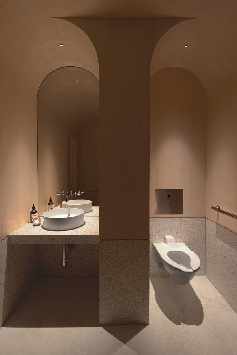 This modern tea store bathroom features an arched ceiling that helps to define the separate areas. #BathroomIdeas #BathroomDesign