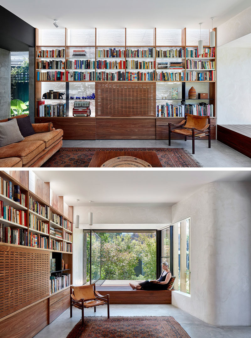 Living Room Ideas - In this modern living room, a wall of shelving surrounds a television, that's hidden from view with a perforated panel. A built-in window seat with a large pivoting window, is the perfect place to read a book and look out to the rear yard. #LivingRoom #HiddenTV #WindowSeat #PivotingWindow #Shelving