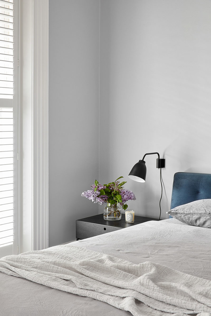 Bedroom Ideas - Simple grey paint with white trim work and modern furnishings, help to create a calm and relaxing atmosphere for this modern bedroom. #BedroomIdeas #ModernBedroom