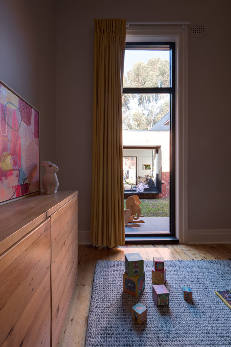 Window Ideas - This modern bedroom has a vertical window that looks out onto a grassy courtyard. #VerticalWindow #WindowIdeas