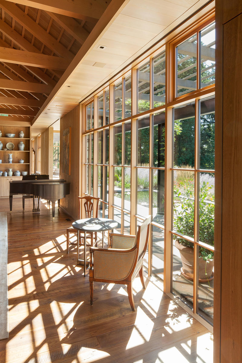 Window Ideas - Window walls in this farmhouse modern living room, allow the gardens to become a part of the home. #Windows #FarmhouseModern #LivingRoom