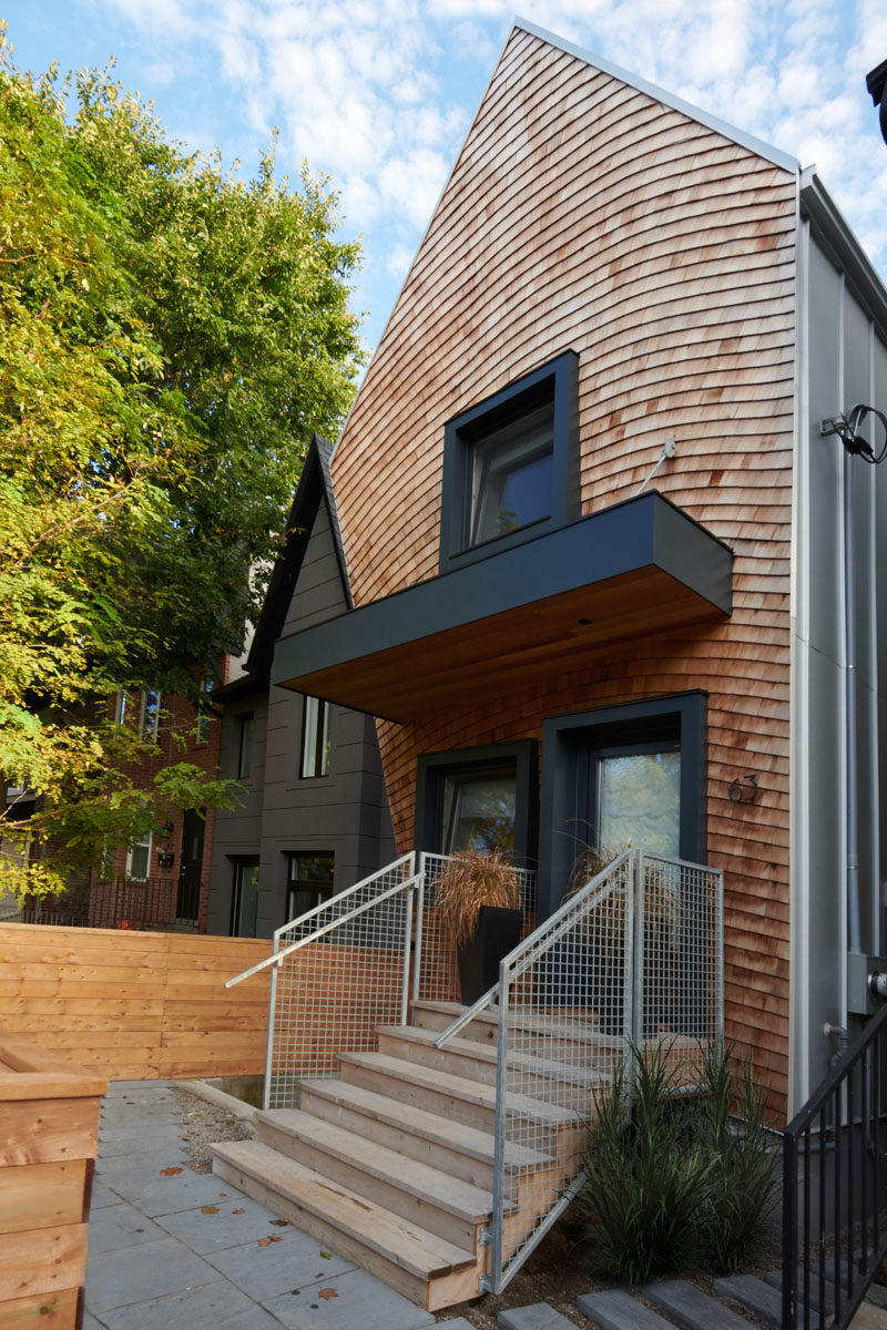 House Design Ideas - This curved house combines wood shingles and black accents for a modern appearance. #Shingles #ModernHouse #BlackWindowFrames #HouseDesignIdeas #CurbAppeal